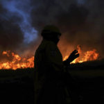
              A firefighter is silhouetted against a raging wildfire in Gouveia, in the Serra da Estrela mountain range, in Portugal on Thursday, Aug. 18, 2022. Authorities in Portugal said Thursday they had brought under control a wildfire that for almost two weeks raced through pine forests in the Serra da Estrela national park, but later in the day a new fire started and threatened Gouveia. (AP Photo/Joao Henriques)
            