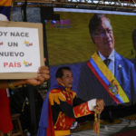 
              Supporters of Colombia's new President Gustavo Petro watch on a giant TV screen his swearing-in ceremony in San Antonio, on the Venezuelan border with Colombia, Sunday, Aug. 7, 2022. (AP Photo/Matias Delacroix)
            