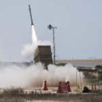 
              An Israeli soldier takes cover as an Iron Dome air defence system launches to intercept a rocket fired from the Gaza Strip, in Ashkelon, southern Israel, Sunday, Aug. 7, 2022. Israel has killed two senior Islamic Jihad militants in three days of air strikes in the Gaza Strip, and Palestinian militants have launched nearly 600 rockets at Israel. Palestinian officials say at least 31 people in Gaza have died. (AP Photo/Ariel Schalit)
            