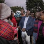 
              Deputy President and presidential candidate William Ruto, center, greets supporters after casting his vote in Kenya's general election in Sugoi, 50 kms (35 miles) north west of Eldoret, Kenya, Tuesday Aug. 9, 2022. Kenyans are voting to choose between opposition leader Raila Odinga and Ruto to succeed President Uhuru Kenyatta after a decade in power. (AP Photo/Brian Inganga)
            