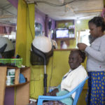 
              A woman gets her hair done in a hair salon in Kibera neighborhood, a stronghold of presidential candidate Raila Odinga, in Nairobi, Kenya, Thursday, Aug. 11, 2022. Kenyans are waiting for the results of a close presidential election in which the turnout was lower than usual. (AP Photo/Mosa'ab Elshamy)
            