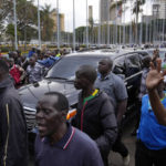 
              Supporters follow the car of Kenyan presidential candidate Raila Odinga as he arrives prior to delivering an address to the nation at his campaign headquarters in downtown Nairobi, Kenya, Tuesday, Aug. 16, 2022. Kenya is calm a day after Deputy President William Ruto was declared the winner of the narrow presidential election over longtime opposition figure Raila Odinga. (AP Photo/Ben Curtis)
            