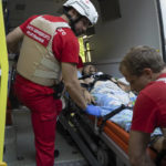 
              Volunteers of Ukrainian Red Cross emergency move a wounded man to an ambulance to transport him from one hospital to another, in Mykolaiv, Ukraine, Tuesday, Aug. 9, 2022. (AP Photo/Evgeniy Maloletka)
            