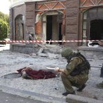 
              Investigative committee officers inspect an area of shelling as a lifeless body lies covered on the ground, in Donetsk, which is under control of the Government of the Donetsk People's Republic, eastern Ukraine, Thursday, Aug. 4, 2022. (AP Photo)
            