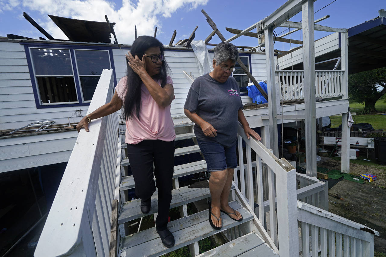 FILE - Louise Billiot, left, a member of the United Houma Nation Indian tribe, walks around the hom...