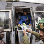 
              A policewoman helps to offload electoral materials from a minibus transporting electoral workers to a collection and tallying center in Nairobi, Kenya Wednesday, Aug. 10, 2022. Kenyans are waiting for the results of a close but calm presidential election in which the turnout was lower than usual. (AP Photo/Ben Curtis)
            