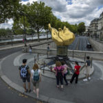 
              People stand by the gilded statue Flame of Liberty that serves as an unofficial shrine to Princess Diana, Monday Aug. 22, 2022 in Paris. It has been nearly 25 years since Princess Diana died in a high-speed car crash in Paris. The French doctor who treated her at the scene has recounted what happened. Dr. Frederic Mailliez told The Associated Press how he tried to save her on that night of Aug. 31, 1997. He remembers speaking English to her, giving here a respiratory bag and calling the emergency services. Diana, her companion Dodi Fayed and their chauffeur died in a car crash in the Alma Tunnel next to the Seine River. (AP Photo/Aurélien Morissard)
            