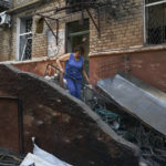 
              A woman cleans up debris in front of a residential building that was damaged after a Russian rocket attack in Kramatorsk, eastern Ukraine, Wednesday, Aug. 31, 2022. (AP Photo/Kostiantyn Liberov)
            