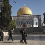 
              Israeli police officers escort a group of Jewish men to visit the Temple Mount, known to Muslims as the Noble Sanctuary, on the Al-Aqsa Mosque compound in the Old City of Jerusalem, during the annual mourning ritual of Tisha B'Av (the ninth of Av) a day of fasting and a memorial day, commemorating the destruction of ancient Jerusalem temples, Sunday, Aug. 7, 2022. (AP Photo/Mahmoud Illean)
            