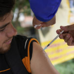 
              Rafael Silva gets his first shot of the Johnson and Johnson vaccine against COVID-19 on the Francisco De Paula Santander Bridge, which connects with Urena, Venezuela, in Cucuta, Colombia, Saturday, Aug. 6, 2022. Many Venezuelans cross the border to get vaccinated against COVID-19. (AP Photo/Matias Delacroix)
            