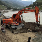 
              Local authorities use heavy machinery to rebuild a damaged road in a flood-affected area, in the town of Bahrain, Pakistan, Tuesday, Aug. 30, 2022. The United Nations and Pakistan issued an appeal Tuesday for $160 million in emergency funding to help millions affected by record-breaking floods that have killed more than 1,150 people since mid-June. (AP Photo/Naveed Ali)
            