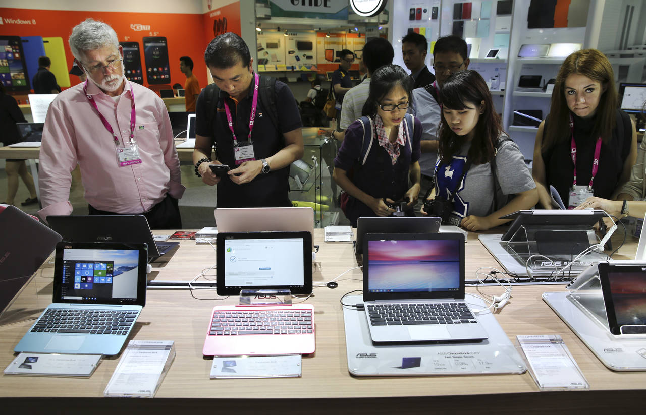 FILE - Visitors review new Asus computer products at the Computex trade show in Taipei, Taiwan, Tue...