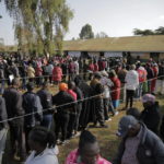 
              People line up to cast their vote in Kenya's general election in Sugoi, 50 kms (35 miles) north west of Eldoret, Kenya, Tuesday Aug. 9, 2022. Kenyans are voting to choose between opposition leader Raila Odinga Deputy President William Rutoto succeed President Uhuru Kenyatta after a decade in power. (AP Photo/Brian Inganga)
            