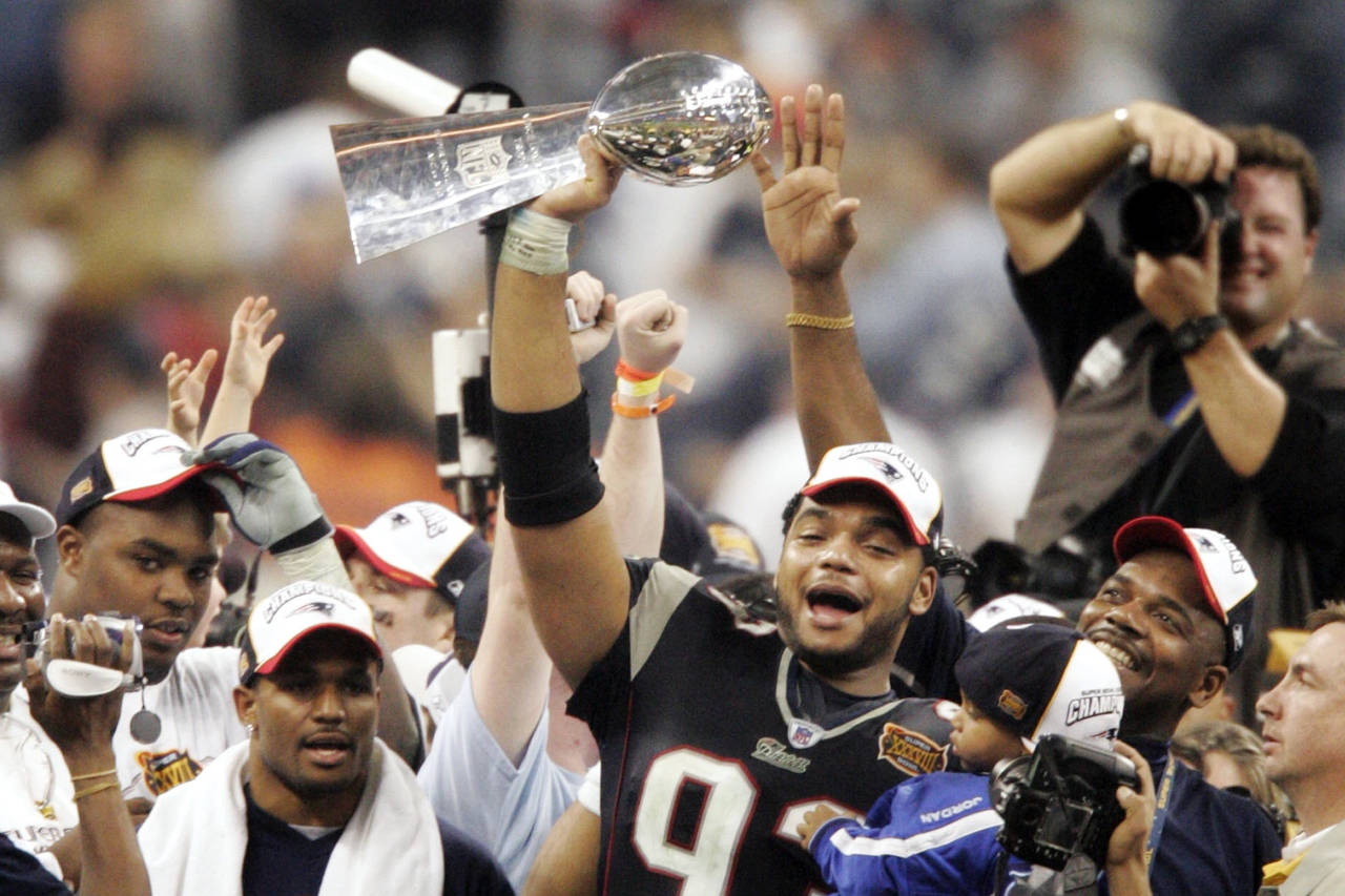 FILE - New England Patriots' Richard Seymour (93) holds the Vince Lombardi trophy after the Patriot...