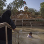 
              Olga Bokkas, a visitor from Connecticut, immerses herself in the waters of the Jordan River at the Qasr al-Yahud baptismal site, near the West Bank town of Jericho on Sunday, July 31, 2022. The river’s dwindling waters are sluggish and a dull brownish green in this area. (AP Photo/Oded Balilty)
            