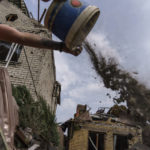
              A worker cleans debris from a rocket strike on a house in Kramatorsk, Donetsk region, eastern Ukraine, Friday, Aug. 12, 2022. There were no injuries reported in the strike. (AP Photo/David Goldman)
            