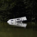 
              A camper is seen partly submerged under water in Carr Creek Lake on Wednesday, Aug. 3, 2022, near Hazard, Ky. (AP Photo/Brynn Anderson)
            
