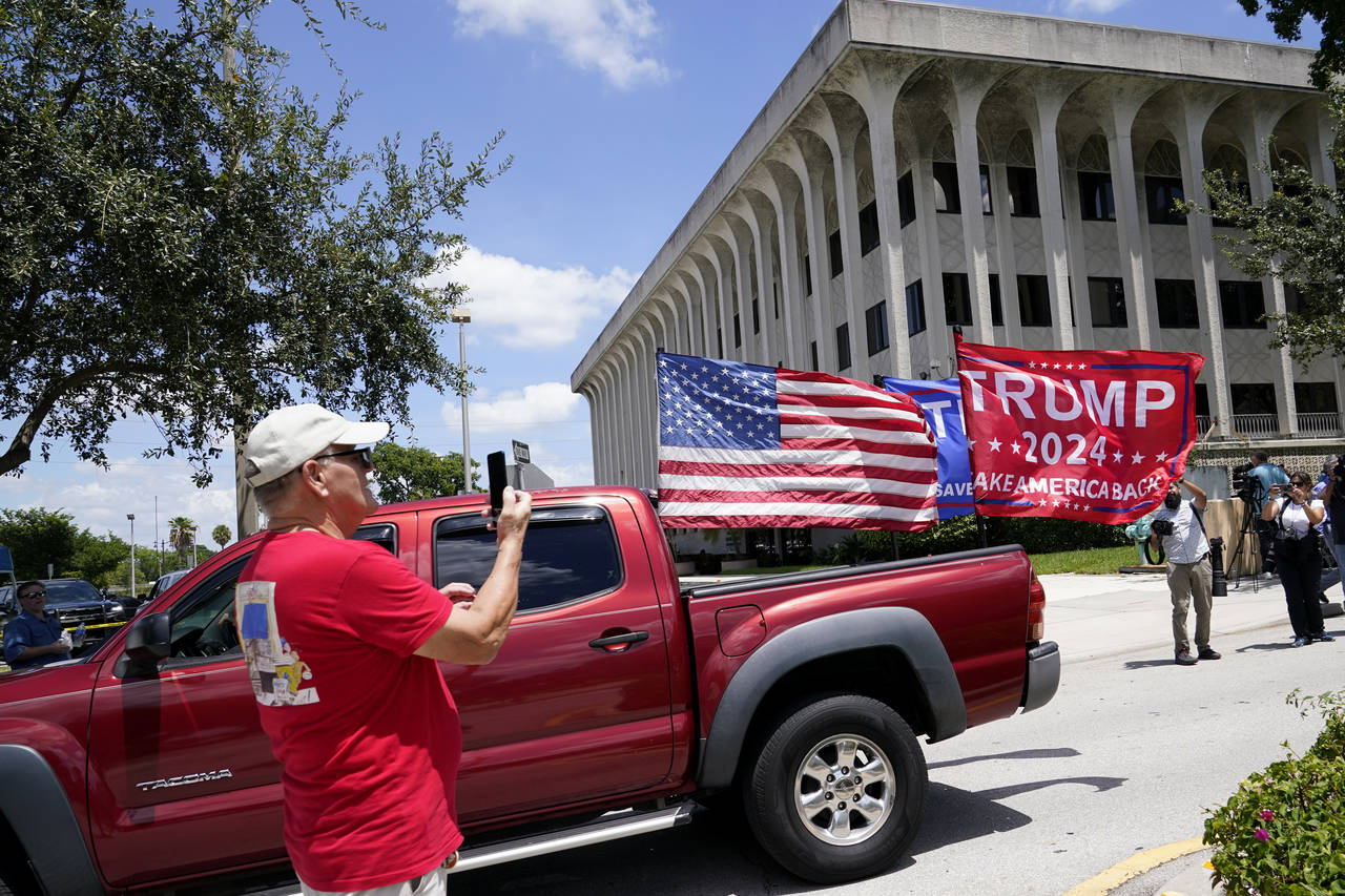 A vehicle with flags in support of Donald Trump drives outside of the Paul G. Rogers Federal Courth...
