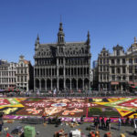 
              The public looks at a giant flower carpet created by volunteers on the historical Grand Place in Brussels, Friday, Aug. 12, 2022. Following an absence of almost two years the flower carpet returns to Brussels with a recreation of the very first carpet from 1971. The flower carpet is put together by more than 120 volunteers who place more than 400,000 begonias in approximately 4 hours. (AP Photo/Virginia Mayo)
            