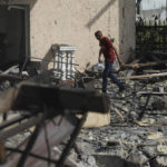 
              A man passes by buildings of local resort destroyed following recent Russian missile attacks in Odesa region, Ukraine, Thursday, Aug. 18, 2022. (AP Photo/Nina Lyashonok)
            