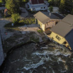 
              FILE - A house sits in Rock Creek after floodwaters washed away a road and a bridge in Red Lodge, Mont., June 15, 2022. This summer the weather has not only been extreme, but it has whiplashed from one extreme to another. Dallas, St. Louis, Kentucky, Yellowstone, Death Valley all lurched from drought to flood. (AP Photo/David Goldman, File)
            