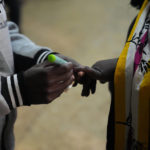 
              An election official marks the hand of a voter at the Kibera primary school in Nairobi, Kenya, Tuesday Aug. 9, 2022. Kenyans are voting to choose between opposition leader Raila Odinga and Deputy President William Ruto to succeed President Uhuru Kenyatta after a decade in power. (AP Photo/Mosa'ab Elshamy)
            