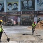 
              Workers clean a street in front of posters that show from left, the late revolutionary founder Ayatollah Khomeini, the Supreme Leader Ayatollah Ali Khamenei, Hezbollah leader Sayyed Hassan Nasrallah, the late Iranian Revolutionary Guard Gen. Qassem Soleimani, the late Iraq's Popular Mobilization forces commander Abu Mahdi al-Muhandis and the late Hezbollah military commander Imad Mughniyeh, in the Lebanese-Israeli border village of Yaroun, south Lebanon, Saturday, Aug. 13, 2022, where the parents of Hadi Matar emigrated from. On Friday, Matar, 24, born in Fairview, N.J., attacked author Salman Rushdie during a lecture in New York. His birth was a decade after "The Satanic Verses" was first published. (AP Photo/Mohammed Zaatari)
            