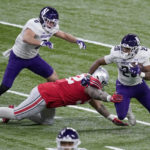 
              FILE - Northwestern running back Cam Porter (20) runs with the ball as Ohio State defensive tackle Haskell Garrett defends and teammate John Raine (0) watches during the first half of the Big Ten championship NCAA college football game, Saturday, Dec. 19, 2020, in Indianapolis. The Big Ten announced Thursday, Aug. 18, 2022, that it has reached seven-year agreements with Fox, CBS and NBC to share the rights to the conference's football and basketball games. (AP Photo/Darron Cummings, File)
            