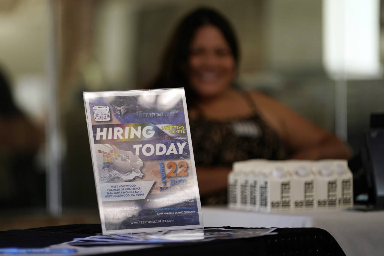 FILE - A hiring sign is placed at a booth for prospective employers during a job fair Wednesday, Se...