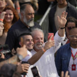 
              Brazil's former President Luiz Inacio Lula da Silva, who is running for reelection, takes a selfie with a supporter during a campaign rally outside the Volkswagen automakers plant in Sao Bernardo do Campo, greater Sao Paulo area, Brazil, Tuesday, Aug. 16, 2022. Brazil's general elections are scheduled for Oct. 2, 2022. (AP Photo/Andre Penner)
            