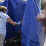 
              Medecins Sans Frontieres doctors treat a man as hundreds of migrants seek shelter outside an overcrowded asylum seekers center in Ter Apel, northern Netherlands, Thursday, Aug. 25, 2022. (AP Photo/Peter Dejong)
            