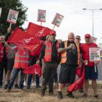 
              Members of the Unite union form a picket line at one of the entrances to the Port of Felixstowe in Suffolk, after backing industrial action by 9-1 in a dispute over pay, Sunday Aug. 21, 2022. Almost 2,000 workers at the U.K.'s biggest container port are launching an eight-day strike Sunday over a pay dispute, the latest industrial action to hit the U.K. economy. (Joe Giddens/PA via AP)
            