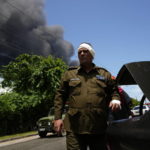 
              A member of the Interior Ministry injured while trying to help in rescue efforts returns to help, near the Matanzas Supertanker Base, where firefighters work to quell a blaze which began during a thunderstorm the night before, in Matazanas, Cuba, Saturday, Aug. 6, 2022. The fire at an oil storage facility raged uncontrolled Saturday, where four explosions and flames injured nearly 80 people and left over a dozen firefighters missing, Cuban authorities said. (AP Photo/Ramon Espinosa)
            