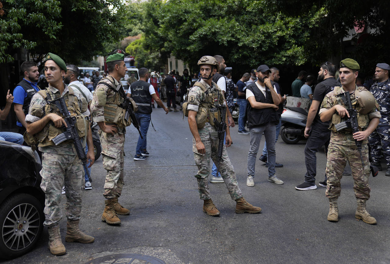 Lebanese soldiers stand guard outside a bank where an armed man has taken hostages, in Beirut, Leba...