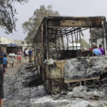 
              Residents walk past a charred truck in El Kala, in the El Tarf region, near the northern Algerian-Tunisian border, Thursday, Aug.18, 2022. Wildfires raging in the forests of eastern Algeria have killed at least 26 people, according to a "provisional report" by the north African country's interior minister. (AP Photo/Mohamed Ali)
            