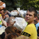 
              Local residents, many of whom fled the war, gather to hand out donated items such as medicines, clothes, and personal belongings to their relatives on the territories occupied by Russia, in Zaporizhzhia, Ukraine, Sunday, Aug. 14, 2022. Volunteers transport these items across the frontline and distribute them to addresses at their own risk. (AP Photo/Andriy Andriyenko)
            