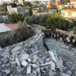 
              Palestinians look at rubble of the house of Asad Rifai after it was demolished by Israeli forces along with the house of of Subhi Sbeihat, both suspected of carrying out a deadly May 2022 attack on Israelis in the city of Elad, near Tel Aviv, in Rummana, near the West Bank city of Jenin, Monday, Aug. 8, 2022. The Israeli military says their soldiers faced a violent protest during the operation. (AP Photo/Majdi Mohammed)
            