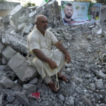 
              A Palestinian sits in the rubble of the house of Asad Rifai after it was demolished by Israeli forces along with the house of of Subhi Sbeihat, both suspected of carrying out a deadly May 2022 attack on Israelis in the city of Elad, near Tel Aviv, in Rummana, near the West Bank city of Jenin, Monday, Aug. 8, 2022. The Israeli military says their soldiers faced a violent protest during the operation. (AP Photo/Majdi Mohammed)
            