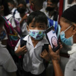 
              CORRECTS LOCATION A boy talks to his mother from a smartphone during the opening of classes at the San Juan Elementary School in metro Manila, Philippines on Monday, Aug. 22, 2022. Millions of students wearing face masks streamed back to grade and high schools across the Philippines Monday in their first in-person classes after two years of coronavirus lockdowns that are feared to have worsened one of the world's most alarming illiteracy rates among children. (AP Photo/Aaron Favila)
            