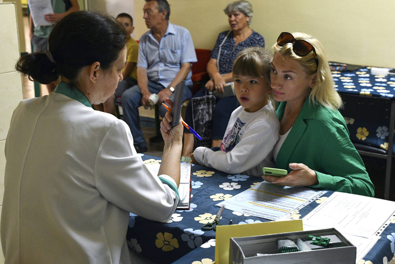 People receive iodine-containing tablets at a distribution point in Zaporizhzhia, Ukraine, Friday, ...