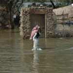 
              A man carries usable belongings salvaged from his flood-hit home across a flooded area in Shikarpur district of Sindh province, of Pakistan, Wednesday, Aug. 31, 2022. Officials in Pakistan raised concerns Wednesday over the spread of waterborne diseases among thousands of flood victims as flood waters from powerful monsoon rains began to recede in many parts of the country. (AP Photo/Fareed Khan)
            