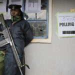 
              A Kenyan officer stands guard at a polling station in Sugoi, 50 kms (35 miles) north west of Eldoret, Kenya, Tuesday Aug. 9, 2022. Kenyans are voting to choose between opposition leader Raila Odinga Deputy President William Ruto to succeed President Uhuru Kenyatta after a decade in power. (AP Photo/Brian Inganga)
            