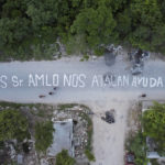 
              A phrase that reads in Spanish “SOS Mr. AMLO. We are being attacked. Help!!!” covers a street in the October 2 squatter settlement in Tulum, Quintana Roo state, Mexico, Thursday, Aug. 4, 2022. The message was written by the squatters, directed at Mexican President Andres Manuel Lopez Obrador after local authorities attempted to evict them from a stretch of public land that was sold by city officials to largely foreign developers. (AP Photo/Eduardo Verdugo)
            
