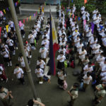 
              CORRECTS LOCATION Students attend a flag raising ceremony during the opening of classes at the San Juan Elementary School in metro Manila, Philippines on Monday, Aug. 22, 2022. Millions of students wearing face masks streamed back to grade and high schools across the Philippines Monday in their first in-person classes after two years of coronavirus lockdowns that are feared to have worsened one of the world's most alarming illiteracy rates among children. (AP Photo/Aaron Favila)
            