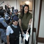 
              WNBA star and two-time Olympic gold medalist Brittney Griner is escorted in a court prior to a hearing, in Khimki, just outside Moscow, Russia, Tuesday, Aug. 2, 2022. Since Brittney Griner last appeared in her trial for cannabis possession, the question of her fate expanded from a tiny and cramped courtroom on Moscow's outskirts to the highest level of Russia-US diplomacy. (AP Photo/Alexander Zemlianichenko)
            