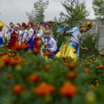 
              Children in traditional Ukrainian clothing run through a field after recording an online video message for the country's upcoming Independence Day on Aug. 24 at a community center in Andriivka, Donetsk region, eastern Ukraine, Friday, Aug. 19, 2022. (AP Photo/David Goldman)
            