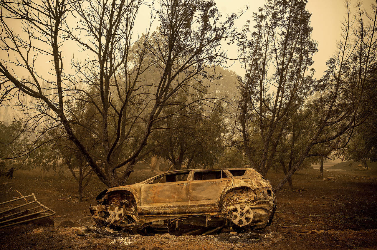 A scorched vehicle rests sits next to a driveway as the McKinney Fire burns in Klamath National For...