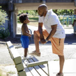 
              Royal Harris, talks to his grandson, Carter, 2, at Woodlawn Park in Portland, Ore., Wednesday, July 20, 2022. Harris, who has lost friends and family to Portland's gang violence, says he supports diverting resources from cold case units to address spiking gun violence in the city. "If the case has been cold for five years and you've got a case that's two days old, which do you have the biggest capacity to find the answer for? I'm going to go with the new (one)," Harris says. (AP Photo/Craig Mitchelldyer)
            