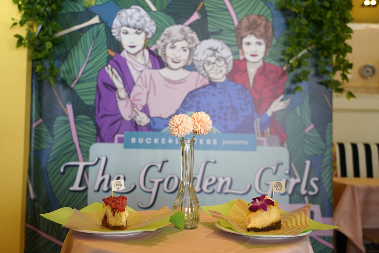 Cheesecake dessert items are pictured in front of a portrait of "The Golden Girls" cast at the Gold...