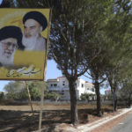 
              Portraits of the late revolutionary founder Ayatollah Khomeini and the Supreme Leader Ayatollah Ali Khamenei, are displayed at the entrance of the Lebanese-Israeli border village of Yaroun, south Lebanon, Saturday, Aug. 13, 2022, where the parents of Hadi Matar emigrated from. On Friday, Matar, 24, born in Fairview, N.J., attacked author Salman Rushdie during a lecture in New York. His birth was a decade after "The Satanic Verses" was first published. (AP Photo/Mohammed Zaatari)
            